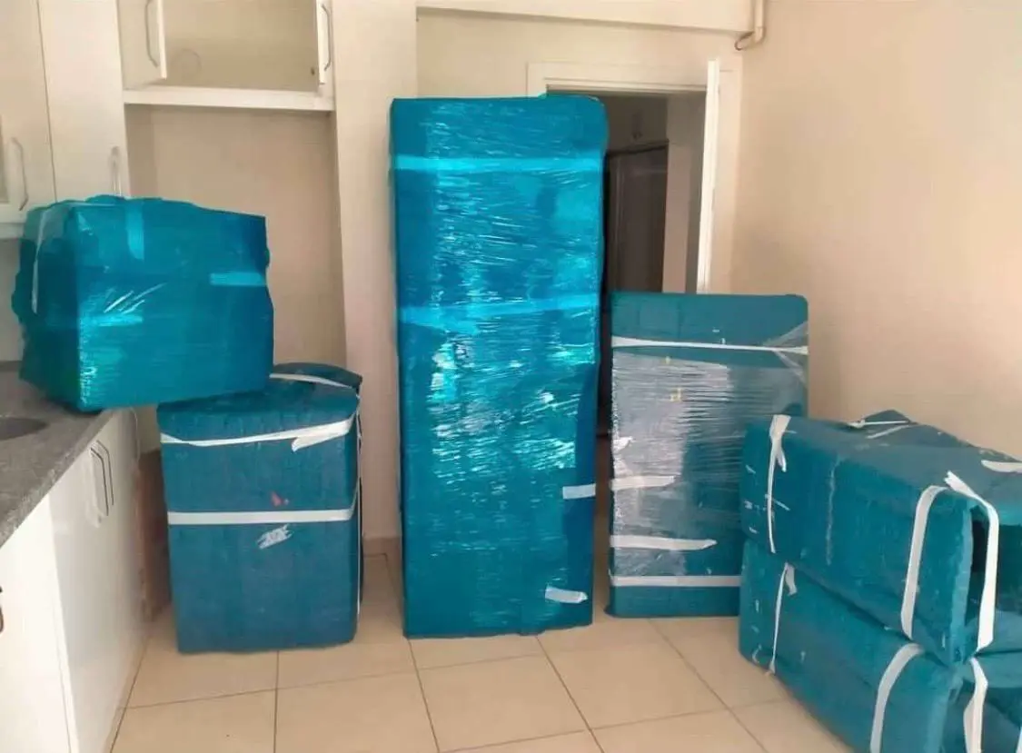 Göktürk nakliyat: turkuaz balonlu naylonla paketlenmiş eşyalar